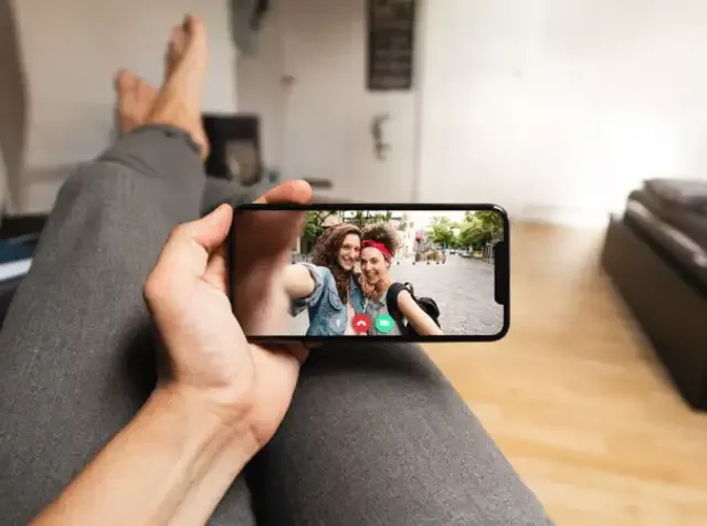 Eine Person verwendet ihr Smartphone für einen Videocall mit Freunden und profitiert dabei von der neuesten Elektronik zu niedrigen Preisen mit dem Pluxee Benefit Elektronik Leasing.