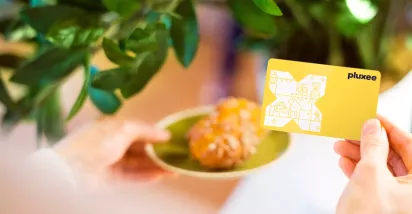 Croissants auf einem Teller mit der Pluxee Benefits Card in gelb