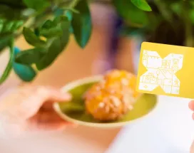 Croissants auf einem Teller mit der Pluxee Benefits Card in gelb